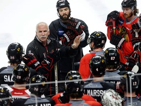 Chicago Blackhawks head coach Joel Quenneville, left, talks to his players at the end of practice Tuesday in Chicago. (AP Photo/Charles Rex Arbogast)