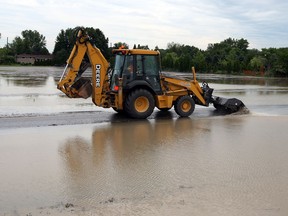 LaSalle Public Works department monitor flooding along Laurier Drive Thursday June 13, 2013. (NICK BRANCACCIO/The Windsor Star)