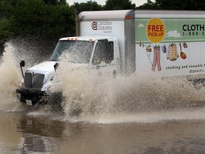 Vehicles continue to travel along Laurier Drive in LaSalle following heavy rains overnight,  Thursday June 13, 2013. (NICK BRANCACCIO/The Windsor Star)