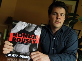 Windsor author Matt Demers holds the cover of his book Ronda Rousey at his home in LaSalle. (TYLER BROWNBRIDGE/The Windsor Star)