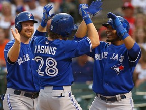 Toronto's Colby Rasmus, centre, celebrates with teammates Adam Lind, left, and Edwin Encarnacion after hitting a three-run homer against the Texas Rangers in the top of the fourth inning at Rangers Ballpark in Arlington Friday. (Photo by Tom Pennington/Getty Images)