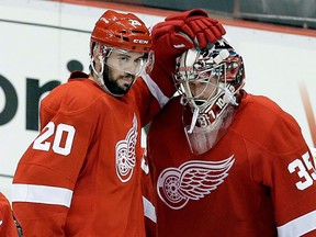 WIngs forward Drew Miller, left, congratulates goalie Jimmy Howard after beating the Chicago Blackhawks 3-1 in the Western Conference semifinal. (AP Photo/Paul Sancya)