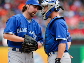 Toronto Blue Jays starting pitcher R.A. Dickey, left, and catcher Josh Thole meet on the mound during the third inning Saturday in Arlington. (AP Photo/Jim Cowsert)