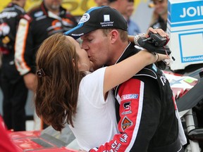 NASCAR Nationwide driver Regan Smith kisses his wife Megan Mayhew after winning the Alliance Truck Parts 250 auto race at Michigan International Speedway Saturday in Brooklyn, Mich. (AP Photo/Bob Brodbeck)