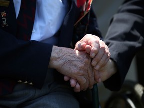 Two Normandy Veterans clasp hands at a remembrance and wreath-laying ceremony to commemorate the start of the D-Day landings at Bayeux War Cemetery on June 6, 2013 in Bayeux, France. (Matt Cardy/Getty Images