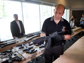 Detective Bob Rodeghiero, with the Gun and Gang Task Force, shows seized firearms during a news conference to update the media about "Project Traveller" at 23 Division in Toronto on Friday, June 14, 2013. "Project Traveller" is a police operation that targeted gun and drug activity across southern Ontario and resulted in 43 arrests and the seizure of 40 firearms and thousands of dollars. (Matthew Sherwood for National Post)