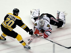 Chicago goalie Corey Crawford, right, knocks the puck away from Boston forward Daniel Paille during the first period in Game 3 of the Stanley Cup finals in Boston Monday. (AP Photo/Charles Krupa)