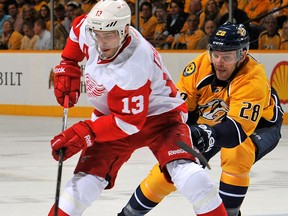 Detroit's Pavel Datsyuk, left, is checked by Nashville's Paul Gaustad. (Photo by Frederick Breedon/Getty Images)