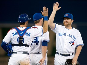Toronto's Adam Lind, right, celebrates with teammates J.P. Arencibia, left, and Casey Janssen after defeating the Colorado Rockies Wednesday. (THE CANADIAN PRESS/Frank Gunn)
