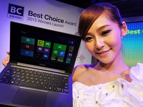 A promoter displays an ASUS "Taichi" laptop computer during a pre-show press conference for the 2013 Computex Taipei show on May 28, 2013. Computex is Asia's biggest annual IT trade fair, which opens on June 4. AFP PHOTO / Mandy CHENG