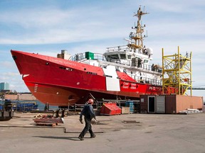 A worker heads past CCGS Corporal Teather C.V., a Hero-class patrol vessel, at the Irving shipyard in Halifax, on Friday, Oct. 19, 2012. Defence Minister Peter MacKay says Ottawa will spend up to $488 million on new vessels for the coast guard.MacKay says construction of between 18 and 21 vessels of varying types will be available for competitive bids by Canadian shipyards that were not selected to build vessels as part of the national shipbuilding procurement strategy. (THE CANADIAN PRESS/Andrew Vaughan)