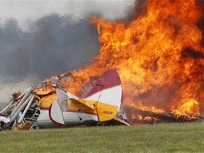 Flames erupt from a plane after it crashed at the Vectren Air Show at the airport in Dayton, Ohio. The crash killed the pilot and stunt walker on the plane instantly, authorities said. (AP Photo/Dayton Daily News, Ty Greenlees)