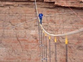 Nik Wallenda walks across a 2-inch wire 1500 feet above the ground to cross the Grand Canyon for Skywire Live With Nik Wallenda on the Discovery Channel, Sunday, June 23, 2013 at the Grand Canyon, Calif. (Tiffany Brown/AP Images for Discovery Communications)