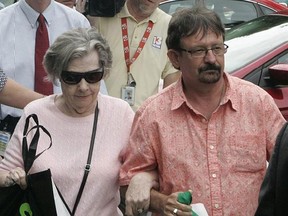 Powerball winner Gloria C. Mackenzie, 84, left, leaves the lottery office escorted by her son, Scott Mackenzie, after claiming a single lump-sum payment of about $370.9 million before taxes on Wednesday, June 5, 2013, in Tallahassee, Fla. Officials say she is the largest sole lottery winner in U.S. history. She did not speak to reporters outside lottery headquarters, leaving in a silver Ford Focus with family members. (AP Photo/Steve Cannon)