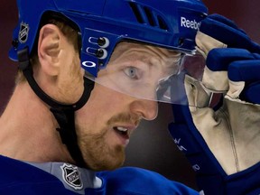 Vancouver Canucks' Henrik Sedin of Sweden, adjusts his helmet during hockey practice in Vancouver on Tuesday April 30, 2013. For the first time, NHL players have overwhelmingly agreed to make visors mandatory for incoming players. But that doesn't mean everything is clear-cut when it comes to visors. (THE CANADIAN PRESS/Darryl Dyck)