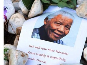 A print of Nelson Mandela and get well messages lay outside the home of the former President Mandela in Johannesburg, South Africa, Saturday, June 15, 2013. Mandela remains in the hospital for a seventh day in critical condition.  (Themba Hadebe , The Associated Press)