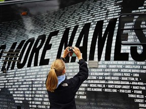 In this file photo, Lindsay Knauf takes a picture of a bus bearing some of the over 6,000 names of people killed by gun violence since the massacre in Newtown at a remembrance event on the six-month anniversary of the massacre at Sandy Hook Elementary School on June 14, 2013 in Newtown, Ct. (Spencer Platt/Getty Images)