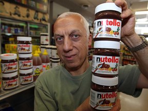 Camille Helou of Service Market in Windsor, Ont., stocks his shelves with Nutella, the popular hazelnut spread Wednesday, June 19, 2013.  The makers of Ferrero Rocher chocolates and Nutella is asking farmers in Essex County to grow hazelnuts for their popular products. (NICK BRANCACCIO/The Windsor Star)