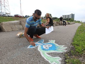 WEtech Alliance and the City of Windsor's Recreation & Culture Department celebrate Social Media Day 2013 along Windsor's waterfront on June 28, 2013. Once again, Mashable is spearheading Social Media Day across the planet. With over 1,500 cities participating, WEtech Alliance and the City of Windsor's Recreation and Culture Department are invited all members of the community to Windsor's Social Media Day 2013 at the Sculpture Park. They attempted to create Windsor's largest social media sidewalk chalk display ever. All participants kept their chalk-thoughts to 140 characters of less (like the popular social media service Twitter). (JASON KRYK/The Windsor Star)