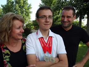 Payton Johnston, centre, graduated from Riverside High School, Wednesday June 26, 2013.  Payton's mother Sandi Johnston, left, and mentor Wes Lemire are proud of his high school diploma and other accomplishments which include two gold medals from the 2012 Provincial Spring Games. (NICK BRANCACCIO/The Windsor Star)