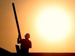 A construction worker is shown atop a roof at sunrise to beat daytime high temperatures, Thursday, June 27, 2013 in Queen Creek, Ariz. Excessive heat warnings will continue for much of the Desert Southwest as building high pressure triggers major warming in eastern California, Nevada, and Arizona. Dangerously hot temperatures are expected across the Arizona deserts throughout the week with a high of 118 by Friday. (AP Photo/Matt York)