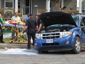 EMS paramedics,  Windsor police and Windsor firefighters transport a victim of an SUV rollover on Assumption Street near Parent Avenue in Windsor, Ontario on June 24, 2013.  Emergency crews responded to the scene after a Ford Escape driven by a woman,  rolled  and came to rest in the middle of the road.   The victim was transported to hospital with unknown injuries and Windsor police are investigating. (JASON KRYK/The Windsor Star)