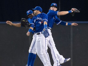 Toronto's Rajai Davis, from left, Jose Bautista and Colby Rasmus celebrate their 4-2 win over Baltimore Saturday. (THE CANADIAN PRESS/Chris Young)