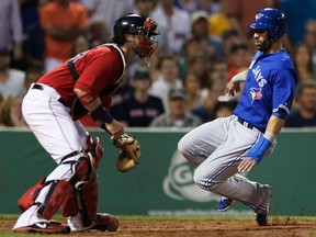 Toronto's  Jose Bautista, right, slides as he beats the ball to Boston catcher Jarrod Saltalamacchia to score on a sacrifice by Adam Lind during the fourth inning at Fenway Park. (AP Photo/Charles Krupa)