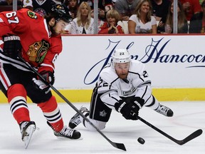 Kings forward Trevor Lewis, right, dives for the puck against Chicago's Michael Frolik during Game 1 of the Western Conference final Saturday in Chicago. (AP Photo/Nam Y. Huh)