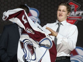 Nathan Mackinnon puts on his jersey after being selected number one overall in the first round by the Colorado Avalanche during the 2013 NHL Draft at the Prudential Center in Newark, New Jersey.  (Photo by Bruce Bennett/Getty Images)