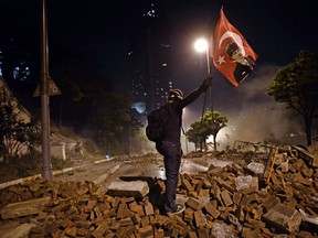 demonstrator waves a Turkish flag with a portrait of Kemal Ataturk between Taksim and Besiktas in Istanbul on June 4, 2013 during a demonstration against the demolition of the park. (ARIS MESSINIS/AFP/Getty Images)