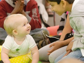 Grade 2 student Ibrahim Ahmed visits with little Abby Comerford at a baby empathy event at Saskatoon's Vincent Massey School on June 10, 2013. (Richard Marjan/Postmedia News)