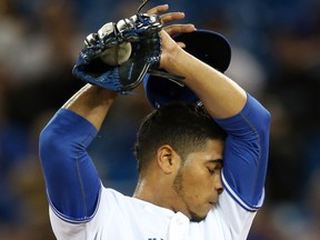 Toronto's Esmil Rogers wipes his face against the Texas Rangers Friday at Rogers Centre in Toronto. (Photo by Tom Szczerbowski/Getty Images)