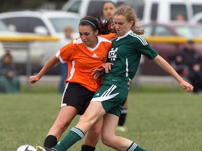 L'Essor's Sophie Gianz, left, battles Jennifer Korsmit of Holy Cross during girls OFSAA soccer in Tecumseh Friday. (TYLER BROWNBRIDGE/The Windsor Star)