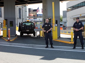 U.S. border officers stand guard at the mouth of the Detroit-Windsor tunnel on Thursday, June 20, 2013. Officials from Canada and the U.S. held a media conference to give tips on crossing the border during the busy summer travel season. (TREVOR WILHELM/The Windsor Star)