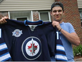 Austen Brassard, 20, hold up a Winnipeg Jets jersey at his Windsor home Sunday, June 2, 2013. The former Spitfire signed a $1.86-million deal with the NHL team. (DAX MELMER/The Windsor Star)
