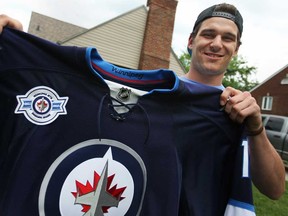 Austen Brassard, 20, holds up a Winnipeg Jets jersey outside his Windsor home Sunday, June 2, 2013. Brassard signed an $1.86-million contract with the Jets. (DAX MELMER/The Windsor Star)