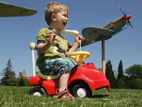 Keegan Haste, 2, plays on his toy car under the World War II memorial replicas of the Hurricane and Spitfire at Jackson Park, Friday, June 14, 2013.  (DAX MELMER/The Windsor Star)