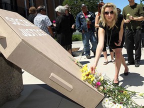 Melisa Larue lays a flower during a rally of support for the Social Justice Centre on the Univerisity of Windsor campus on Monday, June 3, 2013. The university plans to shut the centre down.            (TYLER BROWNBRIDGE/The Windsor Star)     *melisa is correct