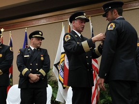 Fire Chief Bruce Montone pins a medal on recruit Ennio Loconte during a swearing in ceremony at the Caboto Club in Windsor on Thursday, June 20, 2013. The new firefighters will now join the fire department as firefighters.               (TYLER BROWNBRIDGE/The Windsor Star)