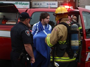 Jason Youkhana, who lives above a commercial unit that caught fire on the 700 block of Wyandotte St. East, speaks with Windsor Fire and Rescue and Windsor police, Thursday, June 6, 2013. (DAX MELMER/The Windsor Star)