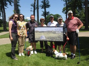 Four golfers played a total of 110 holes at Essex Golf & Country Club. Wednesday to raise $11,000 for the Windsor Humane Society. The cheque presentation included, from left, Katelyn Murray, Amanda Orr, George Kummer, Joyce Cherwak, Michael Naccarato, John Cherwak and Louie Calsavara. In front are Humane Society Alumni: Paddington, Gryphon, Pogo and Humane Society reps Katelyn Murray, Amanda Orr and Joyce Cherwak.