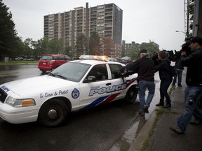 Police drive away after taking a man into custody from the high rise apartment building at 330 Dixon Road. (Matthew Sherwood for National Post)