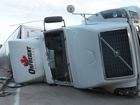 A semi tractor trailer rolled over on Patricia Rd. near the entrance of the Ambassador Bridge at approximately 8:30 p.m. Wednesday, June 5, 2013, in Windsor, Ont. The driver of the truck was not injured. The truck was empty except for plastic pallets that had to be removed from the damaged trailer and transfered to another truck.   (DAN JANISSE/The Windsor Star)