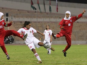 Iranian players Saedeh Ahmadi, left, and Shihrin Nasiri, right, battle for the ball with Stephanie Al-Naber, centre, of Jordan, during the final match at the West Asian Soccer Federation Women's Championship cup in Amman, Jordan on Oct. 1, 2005. The Quebec Soccer Federation announced Sunday it has decided to keep a ban against players wearing turbans on the field. The statement noted that girls are now permitted to wear headscarves on the field in Quebec, following a directive from FIFA in 2012. THE CANADIAN PRESS/AP - Muhammad Al-Kisswany