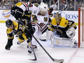 Boston's Patrice Bergeron, centre, and Chicago's Michal Handzus, left, fight for the puck in front of Bruins goalie Tuukka Rask during Game 6 of the Stanley Cup final Monday, June 24, 2013 in Boston. (AP Photo/Elise Amendola)