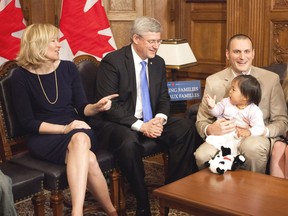 Prime Minister Stephen Harper and his wife Laureen chat with Jeff Watson, Member of Parliament for Essex, and his adopted daughter Beatrice about the expanded Adoption Expense Tax Credit Thursday. (Deb Ransom/PMO))