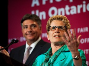 Premier Kathleen Wynne speaks about the budget alongside Finance Minister Charles Sousa at Queens Park in Toronto on Tuesday June 11, 2013. (Aaron Vincent Elkaim/The Canadian Press)