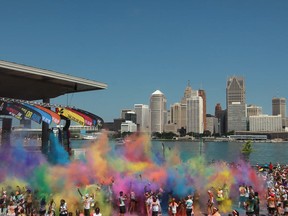 Runners toss coloured powder into the air at The Color Run's Finish Line Festival at the Riverfront Festival Plaza, Saturday, July 20, 2013.  (DAX MELMER/The Windsor Star)