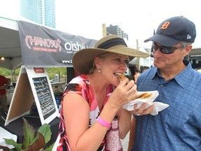 Kelli Jo and Randy Whittaker from Belle River enjoy an egg roll from Chanoso's Oishii during the 2013 fork and Cork Festival at the Riverfront Plaza on July 6, 2013 in Windsor. (JASON KRYK/The Windsor Star)